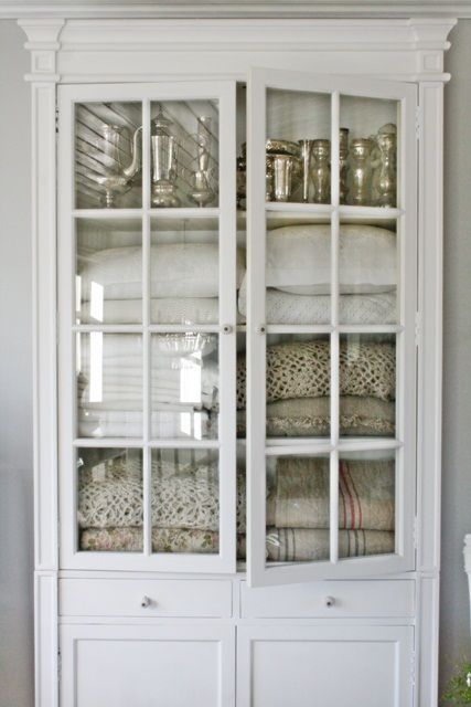 Painted vintage glass front cabinet filled with vintage linens - found on Hello Lovely Studio