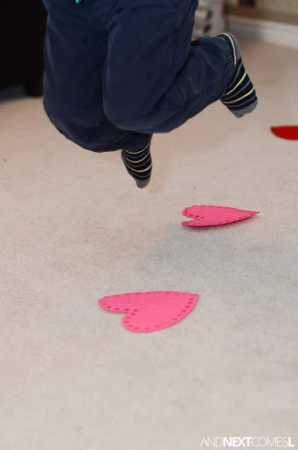 Child jumping over red and pink felt hearts Child jumping over red and pink felt hearts