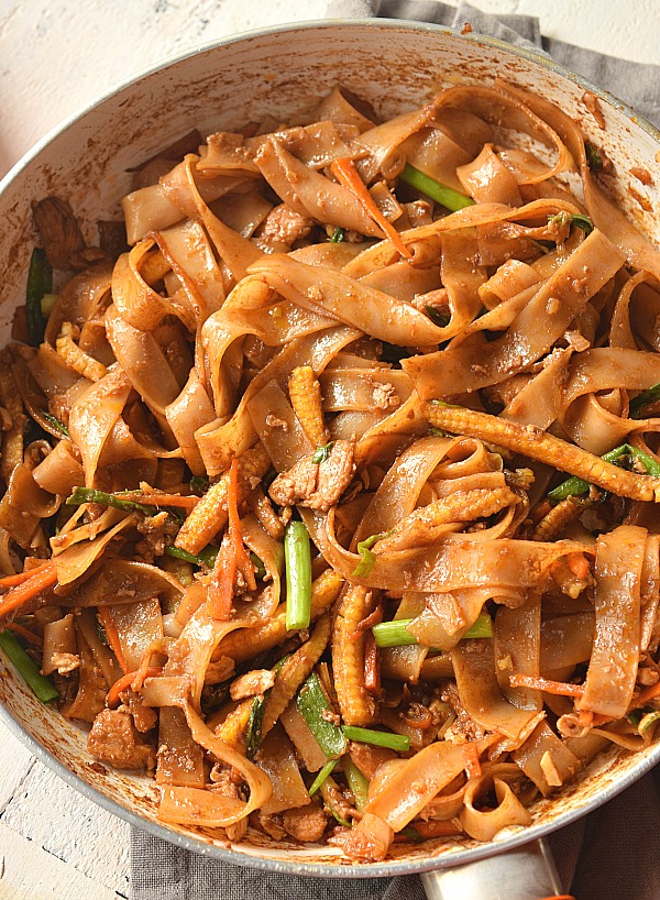 A pan with spicy drunken noodles- easy thai drunken noodles with chicken,eggs and vegetables in spicy sauce