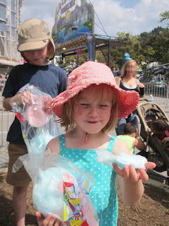 Children eating cotton candy at funfair