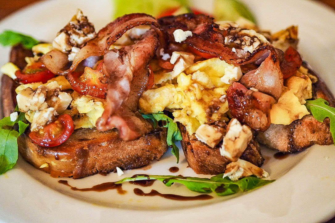 Bacon, scrambled eggs, balsamic glaze on toast with rocket