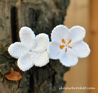 two crochet plumeria flowers