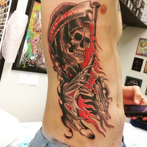 Uma vez brilhante e colorido Grim Reaper tatuagem. O sangue é visto para ser gotejamento da foice, mas é, ao mesmo tempo, a cor do interior manto do reaper. Ele é pintado brilhante e ousadamente.