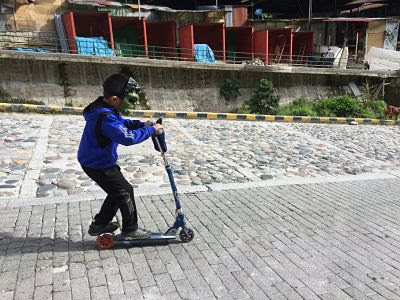 Aguas Calientes Machupicchu Peru. Niño en patinete