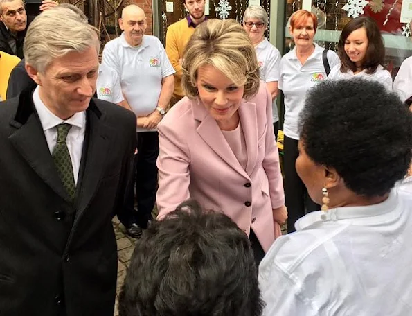 Queen Mathilde wore a light pink top and matching long jacket/coat, combined with grey pants, pink stone earrings at Buurtwerk Chambéry association in Laag Etterbeek