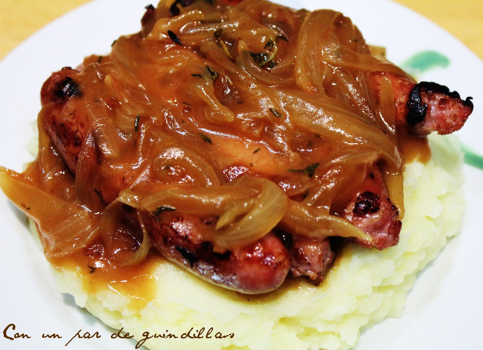 Salchichas con salsa de cebolla y puré de patatas. Con un par de guindillas Gastronomía