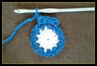 Pictured is the completed face of the crochet watch and the first row of the beginning of the construction of the band of the watch.