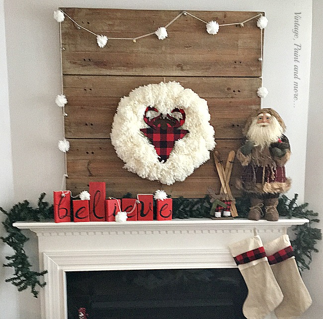 Vintage Paint and more... Rustic Christmase mantel featuring a buffalo plaid deer head in a yarn wreath, a yarn snowball garland and a rustic wood believe sign