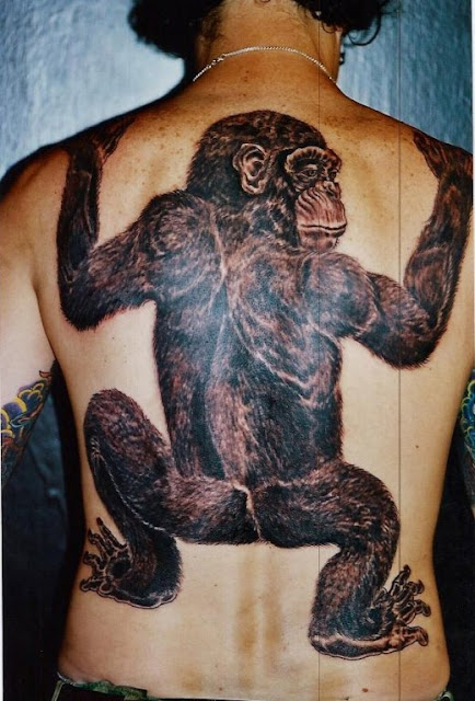 Tatuaje mono trepando en la espalda
