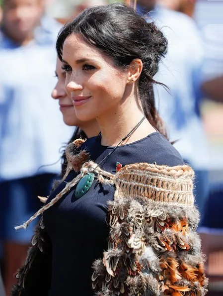 Duchess of Sussex wore Stella McCartney navy asymmetric crêpe dress. Kiri nathan Pounamu Kouma, carved by Jason Nathan