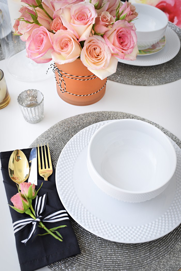 White dinnerware, gold flatware, and a simple floral and candle tablescape make a small space look grand and luxe for entertaining. So many great ideas in this post via monicawantsit.com