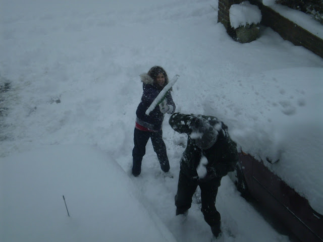 child and father clearing snow
