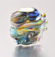 lampworking, glass bead making, handmade glass bead with colored fit and encased