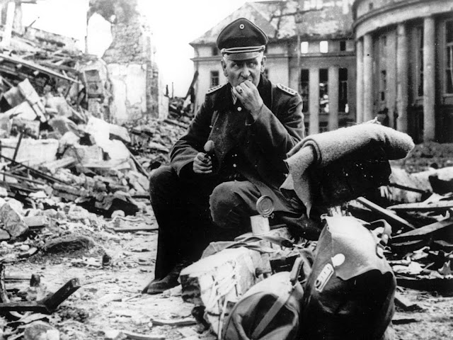 A German officer eats C-rations as he sits amid the ruins of Saarbrücken, a German city and stronghold along the Siegfried Line, in early spring of 1945.