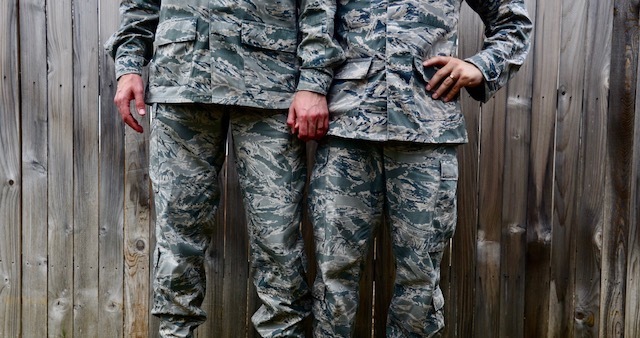 Two military men in uniform stand holding hands, showing a wedding ring. Photo is from the waist to the knees, not revealing the identity of either. (Image credit: U.S. Air Force photo by Staff Sgt. Alexx Pons)
