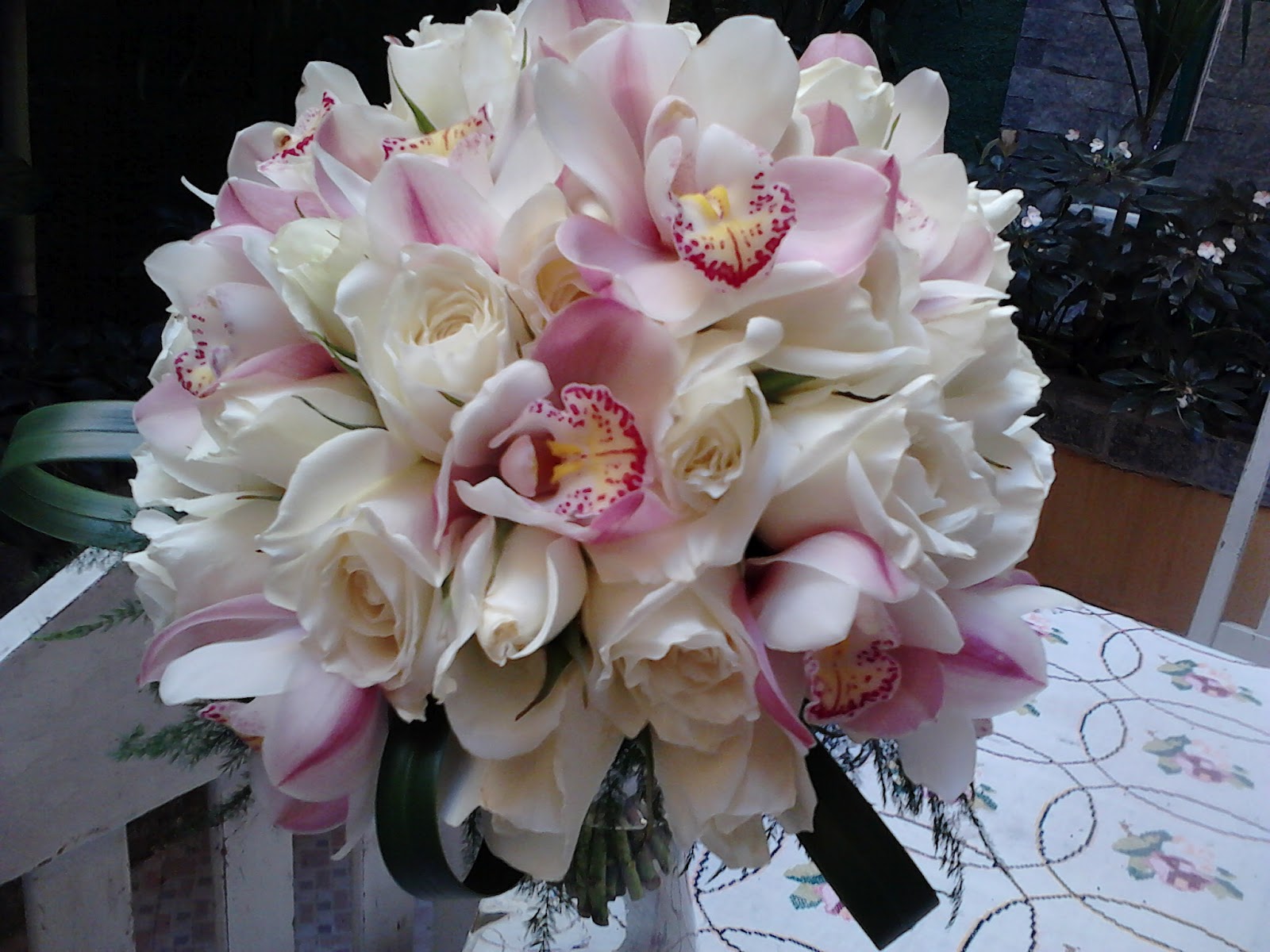 Bouquet de rosas brancas com orquídeas Cimbidium em dois tons de rosa.