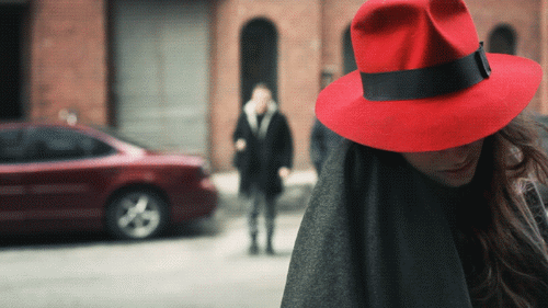 Saçları rüzgarda dalgalanan kırmızı fötr şapkalı bir bayanı gösteren sinemaraf resim