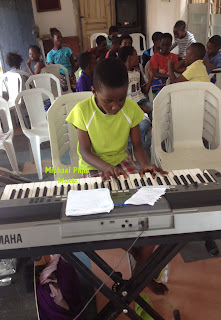 nigerian small boy playing agidigba oo on the piano