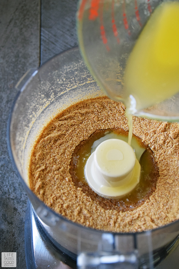 Adding melted butter to the crushed graham crackers to make the crust