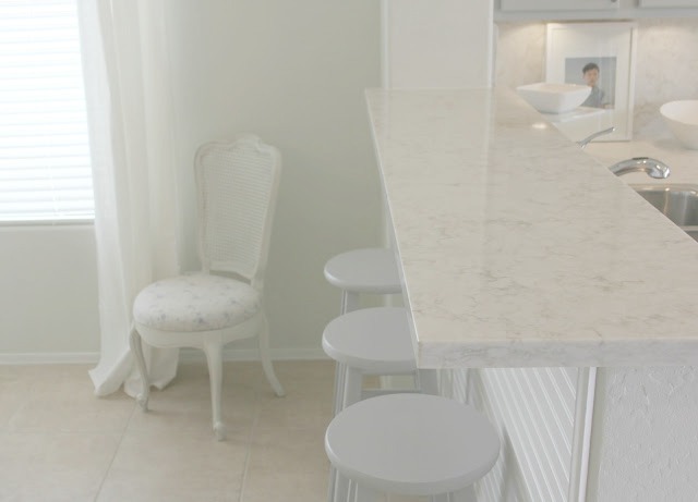 Serene chic simple Nordic French kitchen with grey cabinets and Soprano quartz countertop and backsplash