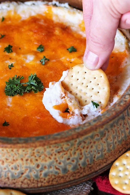 Scooping Baked Hot Crab Dip with a Cracker Image