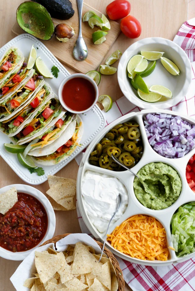 A Guaca-Taco Bar is the ultimate way to feed tacos to a crowd!  Crunchy taco shells are baked in the oven, stuffed with taco meat, and then wrapped with a guacamole smothered flour tortilla to make Guaca-Tacos.  Serve them taco bar-style with all of your favorite classic taco toppings! #GameDayFavorites #OEPGameDay #Sponsored