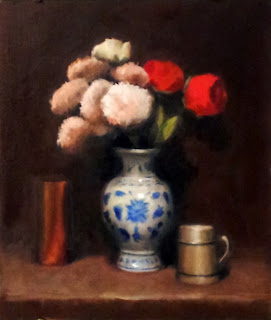 Oil painting of plastic apricot-coloured dahlias and red roses in a blue and white porcelain vase, with a mug on one side and a copper vase on the other.