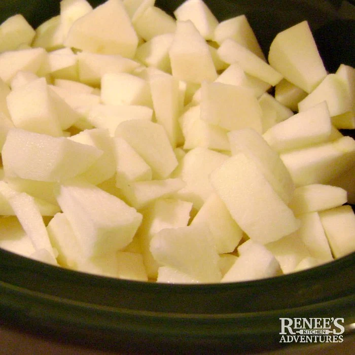 Apples cut up and ready to cook in slow cooker for slow cooker applesauce