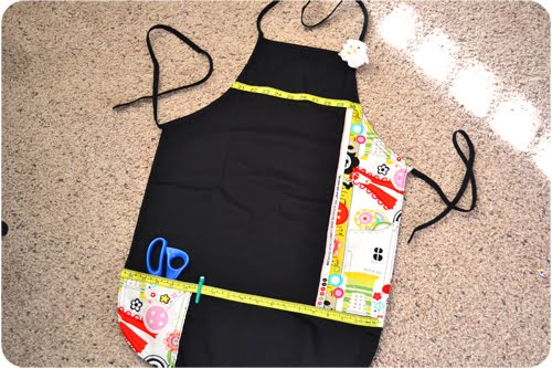 Completed sewing apron with decorative pin cushion attached like a brooch.