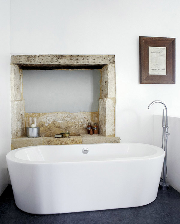 Style mix: Sophisticated | Classic | Rustic | Sleek bathtub and bare stone wall recess in this bathroom via Weranda.