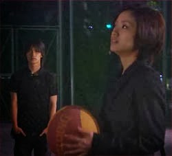 Misaki holding a basketball as she and Nakahara talk on the court.