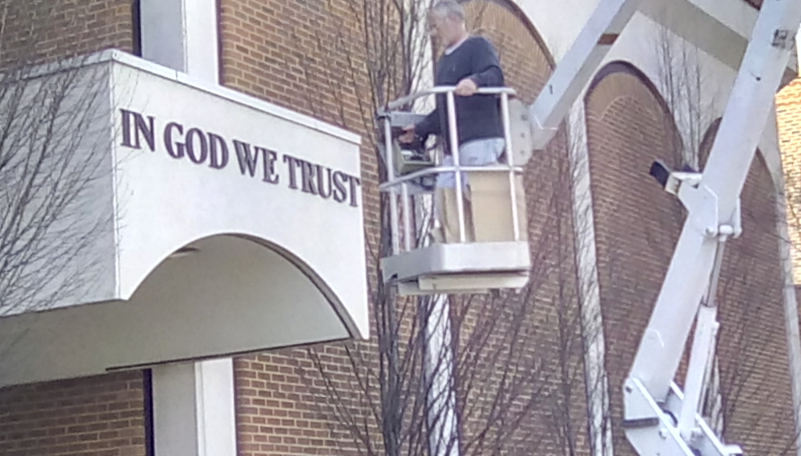 US Motto being installed on side entrance of courthouse