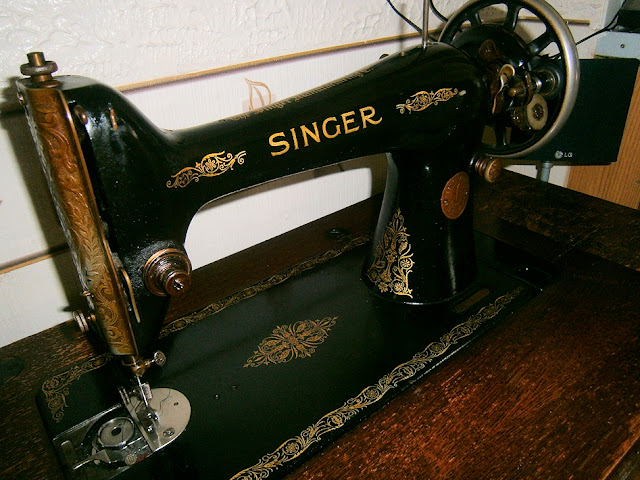 singer sewing machine black on table with draws