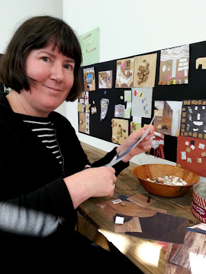 A woman cutting paper for her collage in the children's room at The Daylight Moon exhibition.