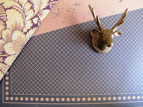 Selection of scrapbooking papers in black and gold, with a gold-painted stag head displayed on them.