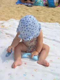 Make an oasis for baby using a sheet on the sand