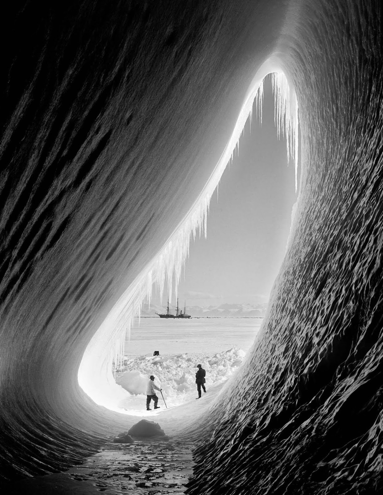 Geologist Thomas Griffith Taylor and meteorologist Charles Wright look out towards the Terra Nova from inside an ice grotto. January 5, 1911.