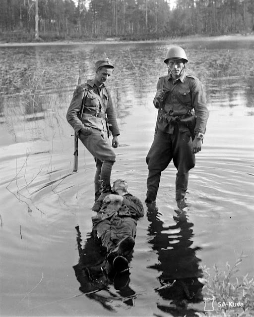 Finnish soldiers pose with Soviet soldier, 31 July 1941 worldwartwo.filminspector.com