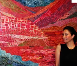 Galia Gluckman with one of her eco artworks - a warm landscape art piece created by using magazine paper clippings