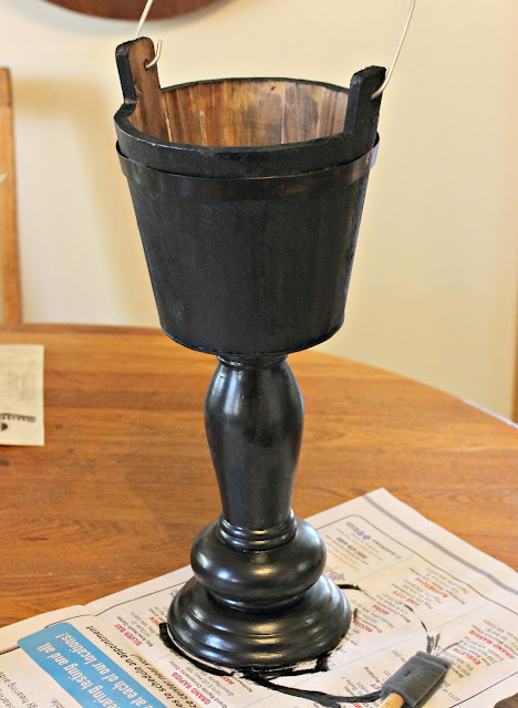 Photo of a bucket pedestal planter painted in a black base coat.
