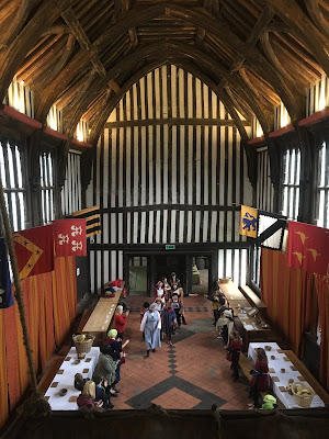 Photograph of Great Hall of Gainsborough Old Hall, imposing room with half timbered walls, vaulted wood ceiling and banners hanging from the walls
