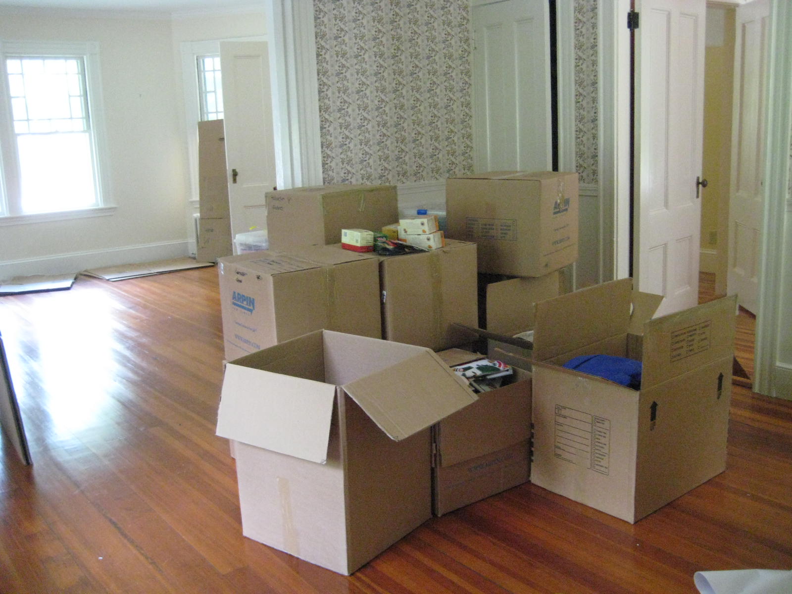Дешево переехать. Коробки в квартире. Комната с коробками. Переезд. Коробки в комнате.