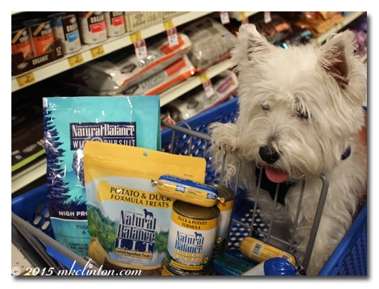 Westie in shopping cart with Natural Balance products