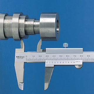Vernier caliper used to measure inside diameters in industrial manufacturing.