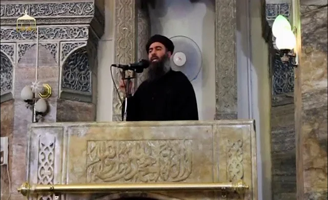 Image Attribute: A man purported to be the reclusive leader of the militant Islamic State Abu Bakr al-Baghdadi making what would have been his first public appearance, at a mosque in the centre of Iraq's second city, Mosul, according to a video recording posted on the Internet on July 5, 2014, in this still image taken from video. REUTERS/Social Media Website via Reuters TV/File Photo 