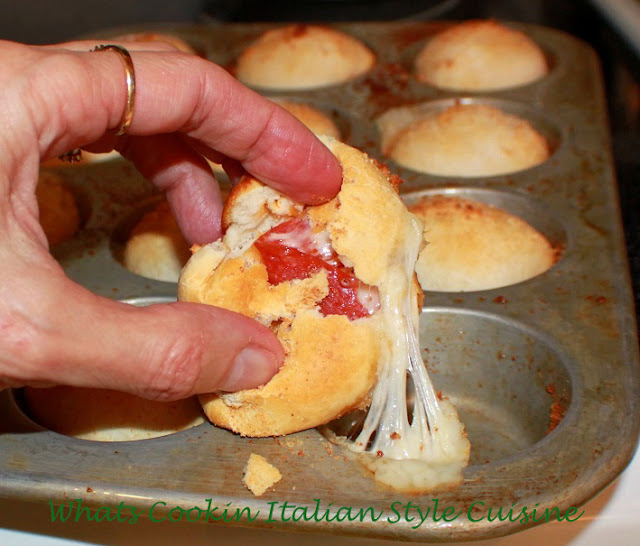 these are homemade pizza dough stuffed with pepperoni, mozzarella cheese and provolone cheese and  placed into a cupcake tin . This stuffed pizza dough after its baked is dipped into a marinara sauce. The photo shows the inside of the pepperoni stuffed pizza with melted cheese oozing out and dipped into the marinara sauce. This recipe shows step by step how to make pepperoni pizza cups