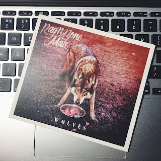 Rag'n'Bone Man's album 'Wolves' resting on a MacBook keyboard. The art features a wolf standing over a metal bowl of raw meat.