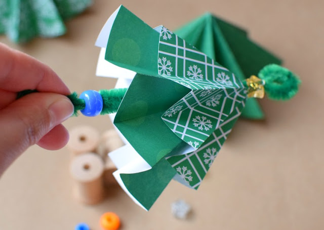 Folded paper Christmas tree ornament craft for kids. Origami is a great fine motor work activity for kindergarten or elementary children!