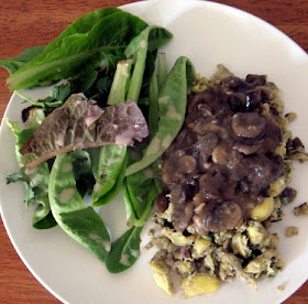 Thanksgiving leftover scramble with egg, mashed potato, olives, artichoke hearts, parsley, mushroom gravy, and a side salad