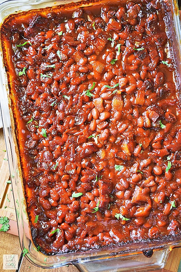Cowboy Baked Beans in baking dish fresh out of the oven with parsley garnish